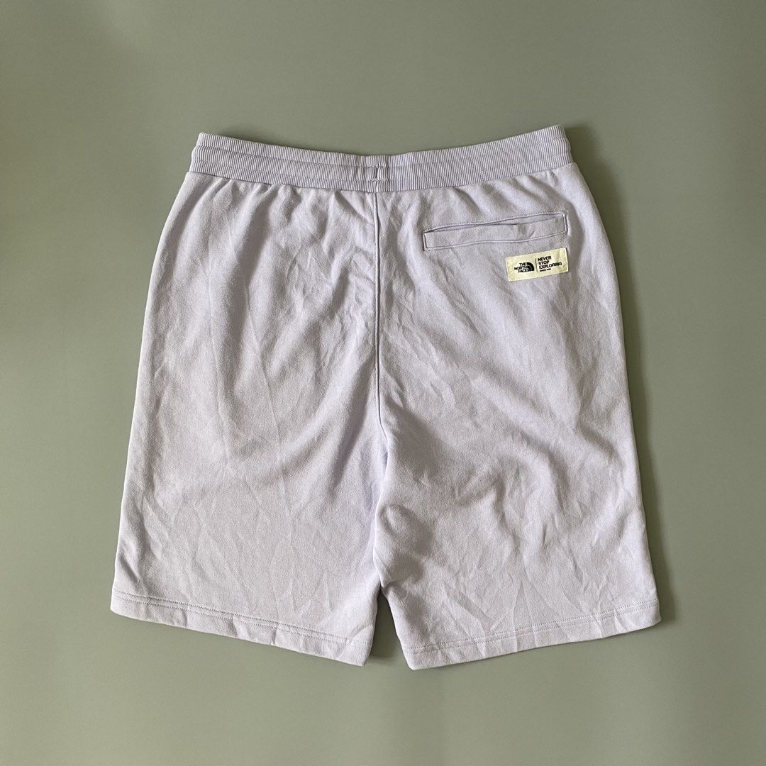 The North Face Purple Sweatshorts (Category: Shorts) located in Manila. Submitted by allthrift07 (Listing ID 1470401310, Image 2). Description: - Brand: The North Face - Style: Fleece sweatshorts / Casual streetwear - Color: Pastel purple - Size: Large (L) - Material: Soft cotton blend - Features: Elastic waistband with white drawstrings, side slant pockets, single back pocket with brand patch, and small embroidered TNF logo near the hem - Condit