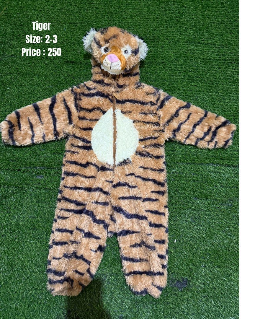 Tiger Costume Size 2-3 (Category: Babies & Kids Fashion) located in San Fernando. Submitted by InvisibleMe (Listing ID 1470450917, Image 1). Description: - Size: 2-3 years old - Design: Brown and black stripes with a cute white belly patch - Hood: Attached hood featuring 3D tiger ears and pink nose detail - Closure: Front zipper for quick and easy dressing/changes - Material: Ultra-soft plush fabric to keep toddlers warm and comfortable.