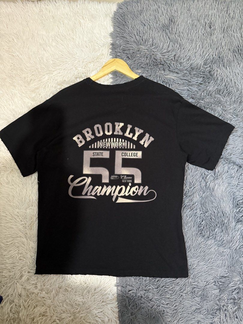 Tiny Toon Adventures Magic Tazo Black T-Shirt (Category: Tshirts & Polo Shirts ) located in Manila. Submitted by keepercollection (Listing ID 1470380765, Image 2). Description: - Color: Black - Design: Tiny Toon Adventures Magic Tazo front graphic; Brooklyn New York State College 55 Champion text and numbers on back - Details: Short sleeves with trendy distressed raw edge on collar and bottom hem - Pit-to-Pit (Chest): ~21.5 inches - Length: ~28.5