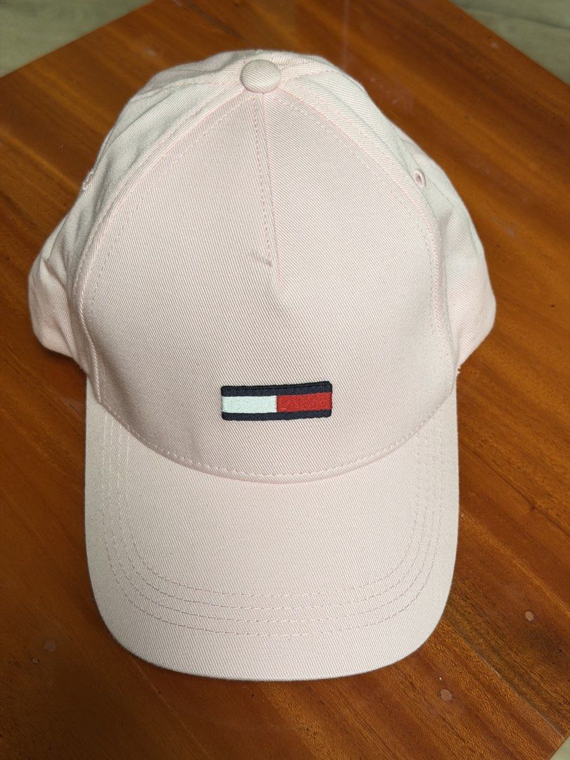 Tommy Hilfiger Light Pink Baseball Cap (Category: Caps & Hats) located in Iloilo. Submitted by caratdeul.17 (Listing ID 1470401037, Image 1). Description: - Brand: Tommy Hilfiger - Color: Beige - Design: Embroidered logo on the front - Fit: Adjustable strap in the back - Structure: Classic curved brim with structured front panel - Condition: Clean fabric, great for casual outfits and sunny days.