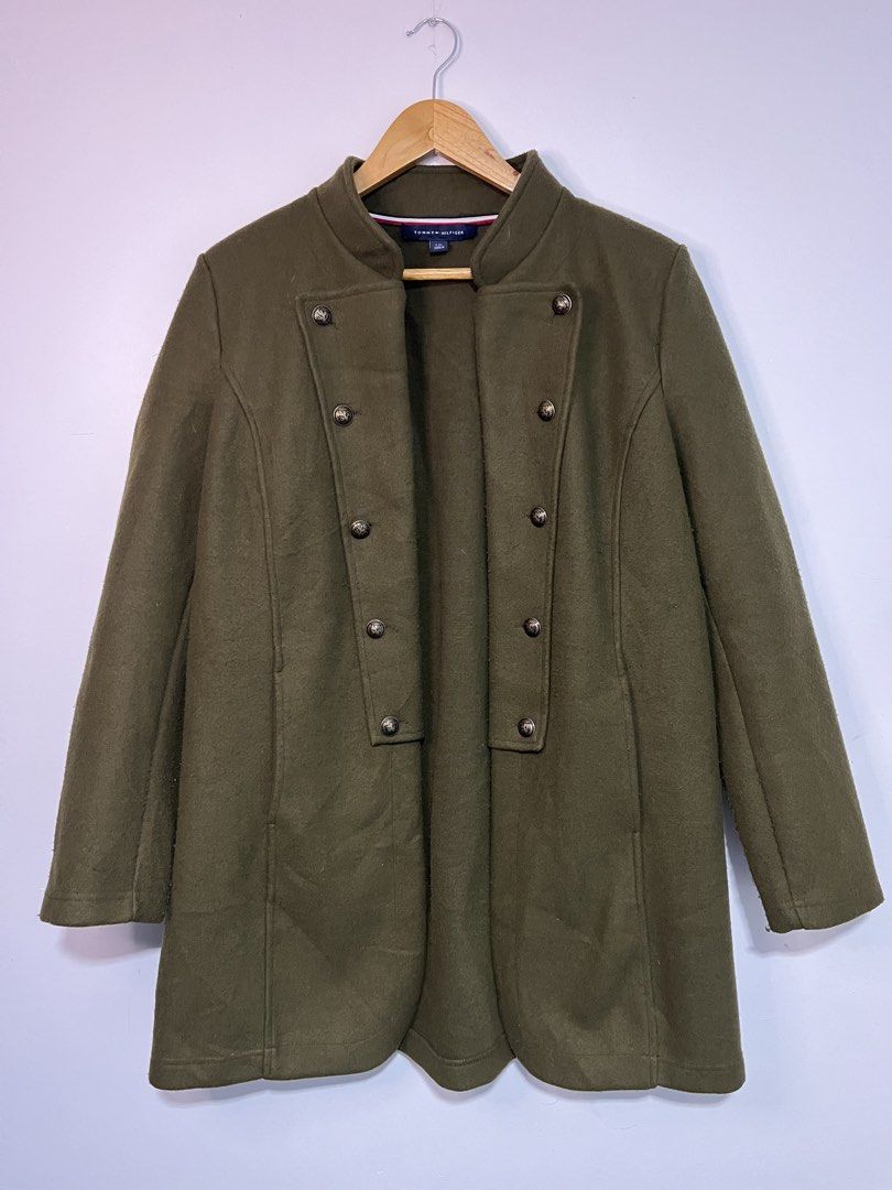 Tommy Hilfiger Olive Green Wool Coat Jacket (Category: Coats, Jackets and Outerwear) located in Dasmarinas. Submitted by thriftedbygii (Listing ID 1470532987, Image 1). Description: - Brand: Tommy Hilfiger - Style: Olive green military-style coat with a structured high collar - Closure: Double-breasted brass front buttons - Size: L - Material: Warm wool-like fabric, ideal for cold weather - Care: Dry clean only.