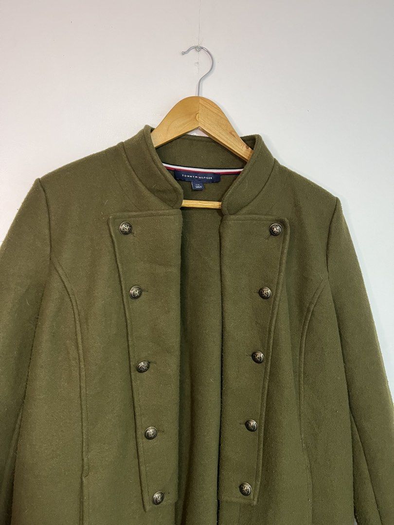 Tommy Hilfiger Olive Green Wool Coat Jacket (Category: Coats, Jackets and Outerwear) located in Dasmarinas. Submitted by thriftedbygii (Listing ID 1470532987, Image 2). Description: - Brand: Tommy Hilfiger - Style: Olive green military-style coat with a structured high collar - Closure: Double-breasted brass front buttons - Size: L - Material: Warm wool-like fabric, ideal for cold weather - Care: Dry clean only.