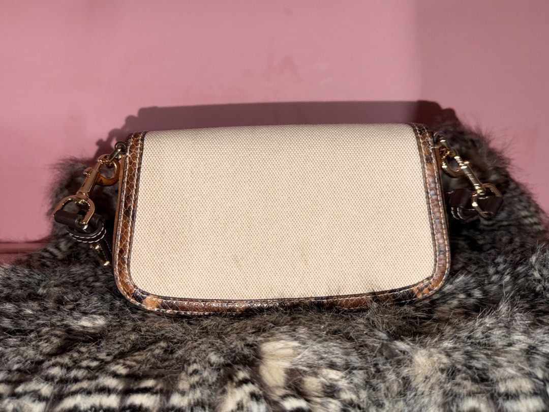 Tory Burch Canvas and Snake Print Shoulder Bag (Category: Shoulder Bags) located in Quezon City. Submitted by parischanelcollection (Listing ID 1470556494, Image 2). Description: - Brand: Tory Burch - Material: Cream canvas with snake print trim and dark brown leather strap - Hardware: Gold-tone clips with prominent double T logo front flap - Interior: Clean chevron-patterned lining with one zippered pocket - Style: Compact, versatile everyday sh
