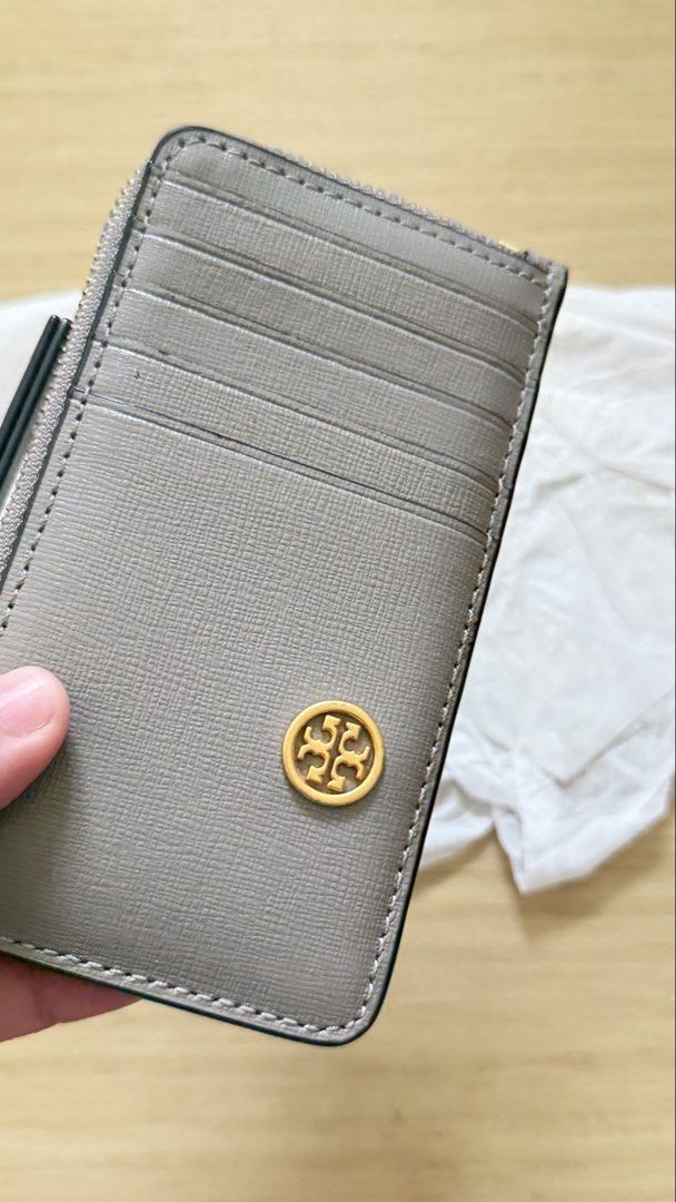 Tory Burch Grey Zip Card Holder (Category: Luxury Bags & Wallets) located in Caloocan City. Submitted by thriftshop_ph (Listing ID 1470430474, Image 2). Description: - Authentic grey Tory Burch card holder made of durable Saffiano leather - Elegant gold hardware and iconic Tory Burch logo - Secure top zip compartment with a convenient leather pull tab - Multiple card slots on both sides for easy organization - Clean interior lining - Brand new in