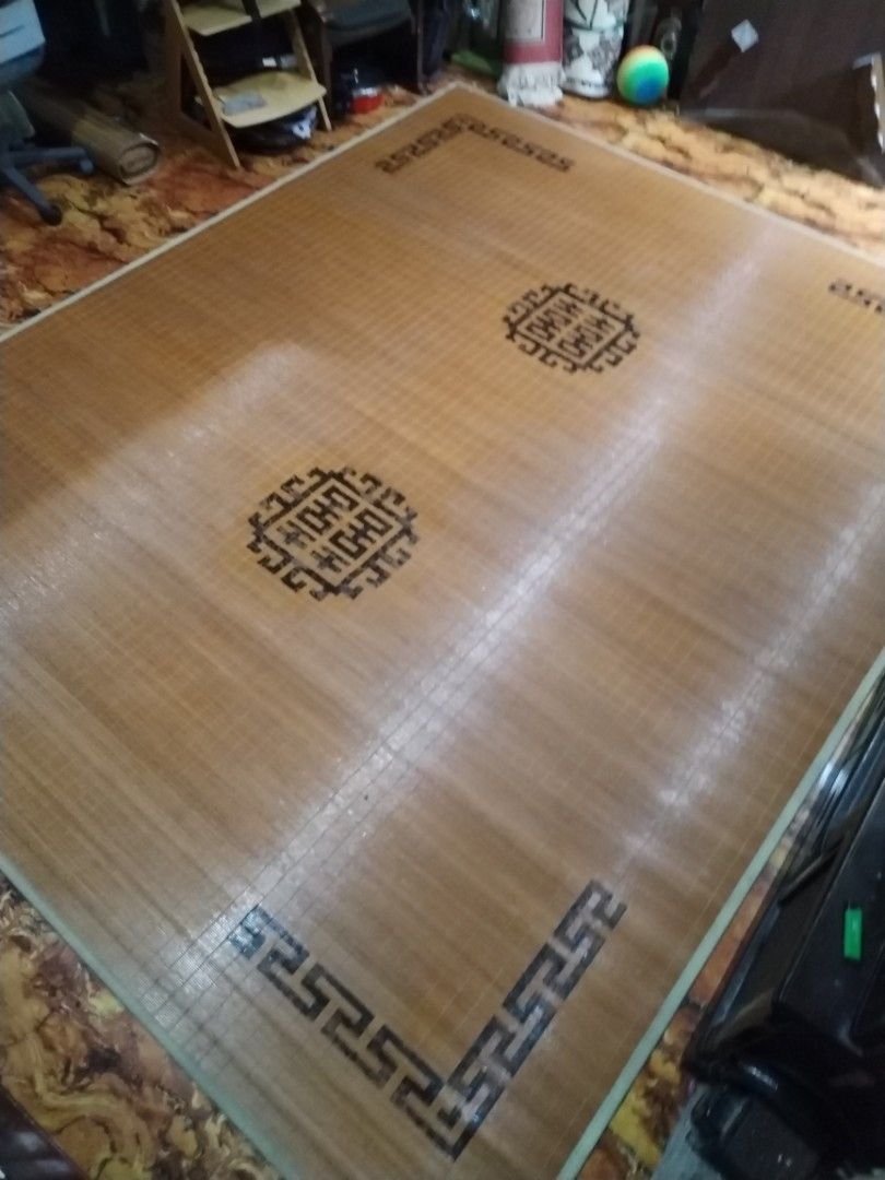 Traditional Asian bamboo sleeping mat with decorative border (Category: Carpets, Mats & Flooring) located in Caloocan City. Submitted by rowely_jpn (Listing ID 1470552597, Image 1). Description: Large bamboo cooling mat for the floor or bed. Smooth wooden slats tied together tightly. Features traditional Chinese geometric key borders and circular medallion patterns in black. Natural wood tones. Keeps cool during warm weather. Rolls up for easy st