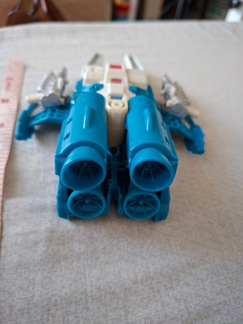 Transformers Tops spin (Category: Vehicle & Diecast Models) located in San Pablo. Submitted by ninojr (Listing ID 1470416246, Image 3). Description: - Item: Transformers Blue & White Jet Toy - Size: Approx. 6 inches long - Details: Features Autobot logo on nose cone, opening clear blue cockpit, dual silver side cannons, and back engine thrusters - Condition: Pre-loved with minor paint chipping on the side wings - Perfect collectible piece for Tra