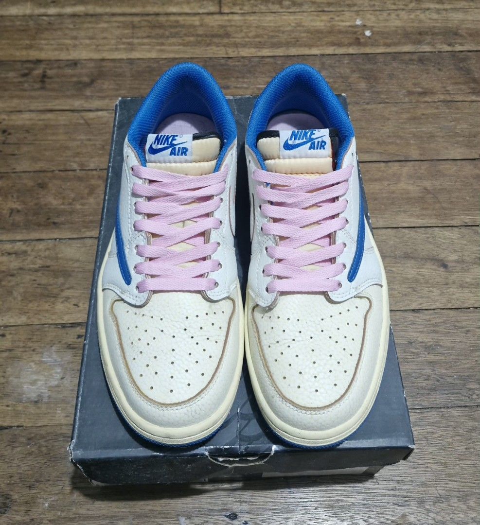 Travis Scott x Nike Air Jordan 1 Low (Category: Sneakers) located in Manila. Submitted by blackstarharpoon (Listing ID 1470526768, Image 2). Description: - Model: Travis Scott Collaboration Low-Top Sneakers - Upper: White tumbled leather - Distinctive Details: Royal blue reverse swooshes and bright pink laces - Interior & Sole: Blue inner lining with matching outsoles - Tongue: Exposed foam no box, replacement only extra laces mid tier.