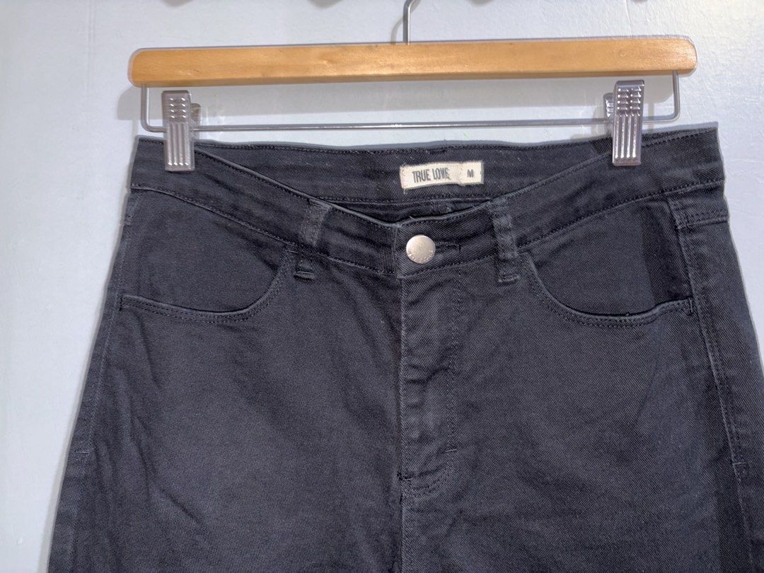 True Love Black Jeans Size M (Category: Jeans) located in Manila. Submitted by margascloset_ (Listing ID 1470492783, Image 3). Description: - Size: M - Color: Classic Black - Design: Front pockets, belt loops, and stylish distressed knee detail - Material: Sturdy denim with a visible twill texture - Condition: has rust stain on the back.