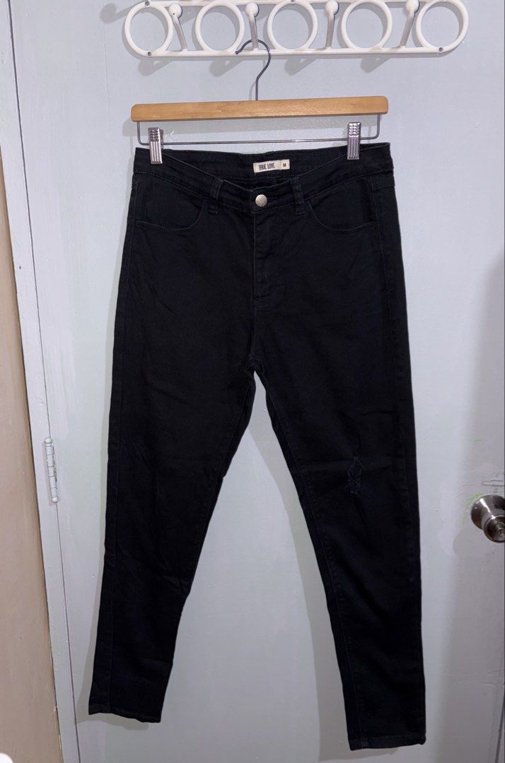 True Love Black Jeans Size M (Category: Jeans) located in Manila. Submitted by margascloset_ (Listing ID 1470492783, Image 1). Description: - Size: M - Color: Classic Black - Design: Front pockets, belt loops, and stylish distressed knee detail - Material: Sturdy denim with a visible twill texture - Condition: has rust stain on the back.