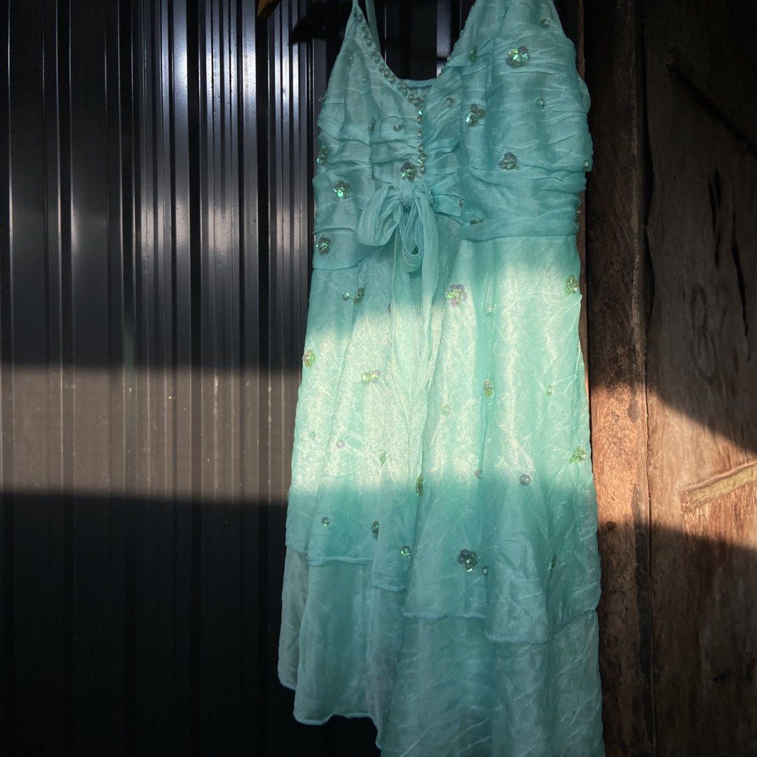 Turquoise Blue Sequin Embellished Reworked Top (Category: Dresses) located in Libungan. Submitted by whimsyypetal (Listing ID 1470550324, Image 3). Description: - Color: Bright turquoise blue - Design: Sleeveless with spaghetti straps and v-neckline - Details: Tiny sequin trim, bodice ruching, and cute tie-up waist bow - Skirt: Layered ruffles with scattered sequin floral accents - Fabric: Lightweight and sheer, perfect for parties and events.