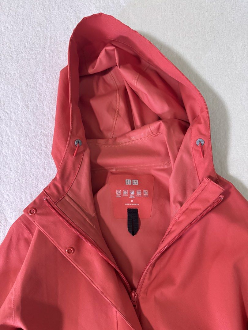 UNIQLO Blocktech Parka Size M (Category: Coats, Jackets and Outerwear) located in Manila. Submitted by mmilaomls (Listing ID 1470404335, Image 3). Description: - Brand: UNIQLO - Color: Red Orange - Size: Medium (M) - Features: Water resistant, windproof, durable water repellency, breathable, and stretch fabric - Design: Full front zip with snap button flap overlay, and adjustable hood with drawstrings and toggles - Condition: Clean inner lining a