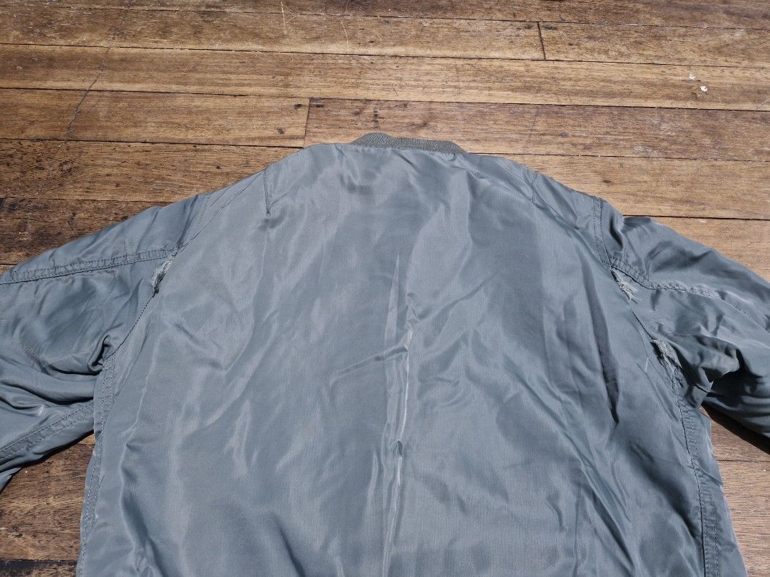 Uniqlo Bomber Jacket (Category: Coats, Jackets and Outerwear) located in Manila. Submitted by blackstarharpoon (Listing ID 1470526297, Image 2). Description: - Style: Classic flight bomber jacket in trendy sage green - Features: Full zip front, ribbed collar/cuffs/hem, sleeve utility pocket with zipper, and two slanted front pockets - Condition: Good overall wear, with minor seam tears near both underarm areas (see close-up photo) - Versatility: 