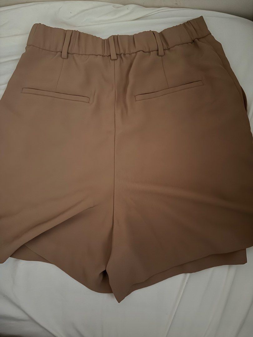 Uniqlo Brown Tailored Shorts Size M (Category: Shorts) located in Manila. Submitted by declutterwidme (Listing ID 1470354402, Image 3). Description: - Brand: Uniqlo - Color: Brown - Size: M (Waist: 63-69 cm, Hips: 88-94 cm) - Material: 100% Polyester - Waistband: Elastic at the back with belt loops - Closure & Style: Front button closure with stylish pleats - Pockets: Two back pocket details - Condition: Excellent / Great find! Almost new.