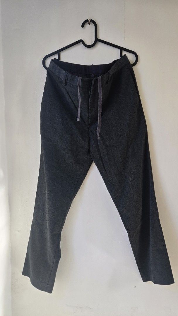 Uniqlo Dark Grey Smart Drawstring Trousers (Category: Trousers) located in General Trias. Submitted by gratsimaravilla (Listing ID 1470484689, Image 1). Description: - Color: Dark Grey - Style: Smart casual / Relaxed fit - Waist: Adjustable drawstring with zip fly and button closure - Pockets: Two back welt pockets with button details - Condition: Noticeable minor stitch fraying along the crotch seam (shown in closeups), but still very wearable f