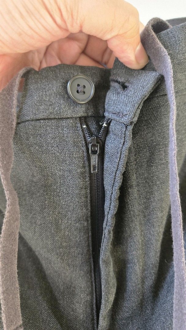 Uniqlo Dark Grey Smart Drawstring Trousers (Category: Trousers) located in General Trias. Submitted by gratsimaravilla (Listing ID 1470484689, Image 3). Description: - Color: Dark Grey - Style: Smart casual / Relaxed fit - Waist: Adjustable drawstring with zip fly and button closure - Pockets: Two back welt pockets with button details - Condition: Noticeable minor stitch fraying along the crotch seam (shown in closeups), but still very wearable f