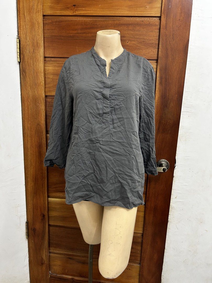 Uniqlo Grey Long Sleeve Button Blouse (Category: Longsleeves) located in Valencia. Submitted by crizzagella20 (Listing ID 1470545539, Image 1). Description: - Brand: Uniqlo - Color: Dark Grey - Size: Large - Style: Mandarin collar, partial button placket, relaxed fit with back box pleat - Material: Rayon and polyester blend - Condition: Great versatile basic for daily casual wear or office outfits.