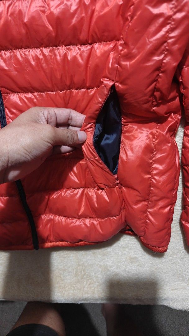 Uniqlo Red Down Jacket Puffer Coat (Category: Coats, Jackets and Outerwear) located in Manila. Submitted by bunnyf2600 (Listing ID 1470510417, Image 3). Description: - Authentic Uniqlo down jacket - Color: Bright red with dark navy lining - Material: 90% down and 10% feather filling for superior warmth - Super lightweight, compact, and easy to pack - Features a smooth zip-up front closure - Practical side zippered pockets to keep hands warm - Per