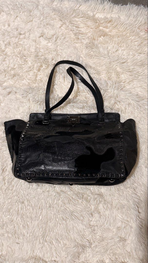 Valentino Exotic Leather Rockstud Shopper Tote (Category: Luxury Bags & Wallets) located in Pasay City. Submitted by erinsclosetph (Listing ID 1470510304, Image 2). Description: Exotic Leather Rockstud Shopper Tote w/ detachable strap. Relaxed shape, wear on corners, creasing on sides, hairline scratching on hardware, clean interior. Brand: Valentino Colour: Black Pattern: Camoflage Fabric: Leather Condition: Excellent Dust Bag: With Dust Bag Cat