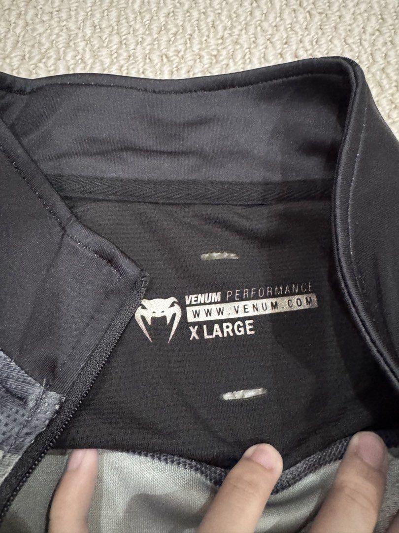 Venum Performance Grey Black Quarter Zip Training Top (Category: Activewear) located in Valenzuela. Submitted by crabncorn (Listing ID 1470363474, Image 3). Description: - Brand: Venum Performance - Size: Extra Large (XL) - Color: Grey and black - Design: Quarter zip mock neck with branded zipper pull - Breathability: Mesh shoulder panels - Details: Screen-printed Venum snake logo on chest and Performance Apparel compass graphic on right chest.