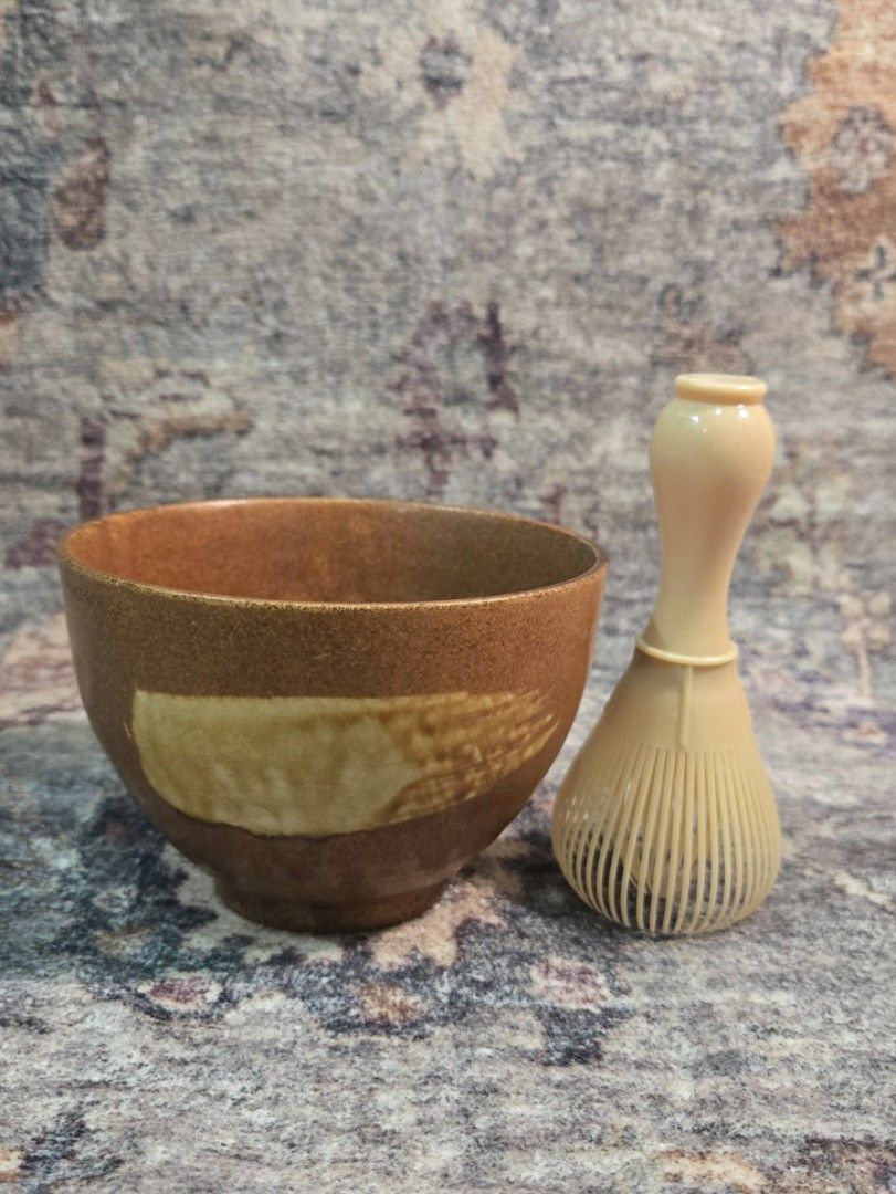 Vintage studio hakeme tea bowl (Category: Coffee & Tea Tableware) located in Manila. Submitted by cwknds (Listing ID 1470516124, Image 3). Description: ​an authentic japanese studio stoneware tea bowl (yunomi). finished in a warm cinnamon ash glaze and accented by a gestural cream hakame slip brushstroke across the front. the base features an impressed artisan studio seal (kamajirushi) on the raw terracotta foot ring. (chasen shown for scale comp