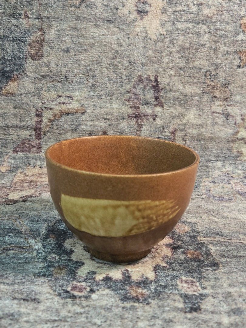 Vintage studio hakeme tea bowl (Category: Coffee & Tea Tableware) located in Manila. Submitted by cwknds (Listing ID 1470516124, Image 1). Description: ​an authentic japanese studio stoneware tea bowl (yunomi). finished in a warm cinnamon ash glaze and accented by a gestural cream hakame slip brushstroke across the front. the base features an impressed artisan studio seal (kamajirushi) on the raw terracotta foot ring. (chasen shown for scale comp
