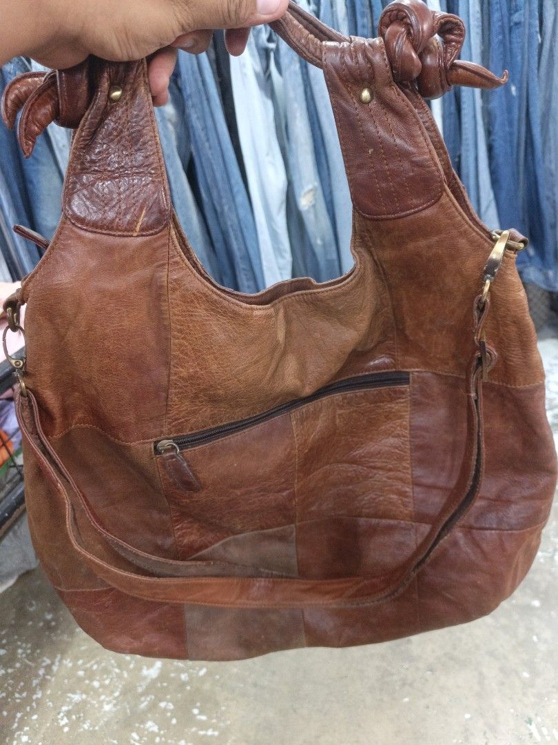 Vintage Brown Leather Patchwork Hobo Shoulder Bag with Eyelets (Category: Shoulder Bags) located in San Carlos City. Submitted by dhong_abay_thrift (Listing ID 1470351161, Image 3). Description: Brown leather shoulder bag. Patchwork construction with intricate stitching details, brass-tone eyelets, and wooden-look button accents on the front. Double structured handles with knot ties. Additional long adjustable strap attached on the sides. Back fe