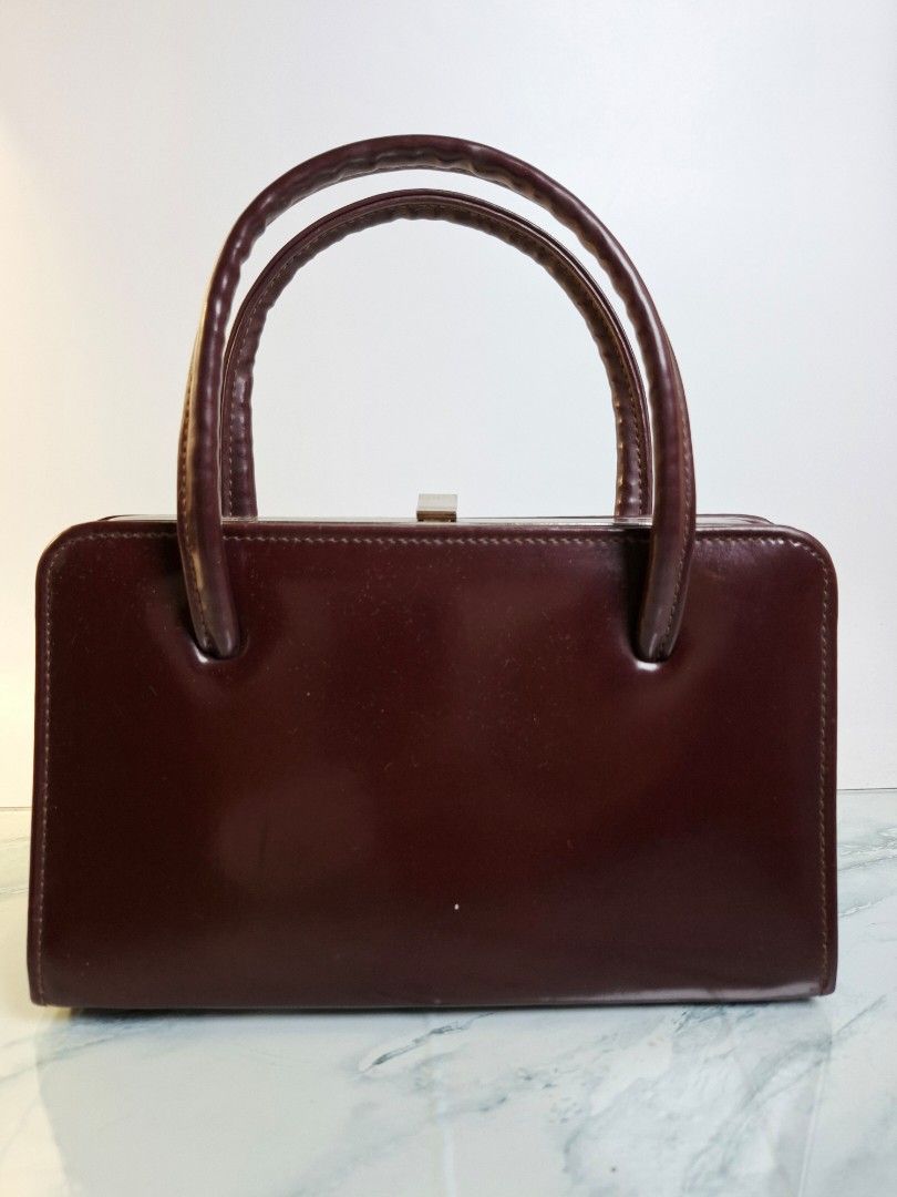 Vintage Burgundy Structured Handbag (Category: Shoulder Bags) located in Pasay City. Submitted by onick_79 (Listing ID 1470405764, Image 1). Description: - Dimensions: L 22.5 x H 14 x W 8 cm - Color: Deep burgundy - Material: Premium structured leather - Design: Classic retro style with a clean, rigid rectangular silhouette - Handles: Comfortable double rolled top handles - Closure: Secure metal frame with a top latch mechanism - Interior: Simple