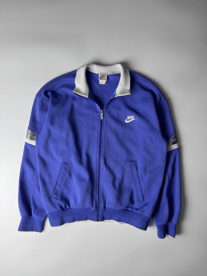 Vintage Nike Blue Track Jacket Full Zip (Category: Coats, Jackets and Outerwear) located in Cavite. Submitted by dracokidstuff (Listing ID 1470393731, Image 1). Description: - Color: Vibrant blue with white accents - Brand: Nike - Features: Embroidered swoosh, sleeve stripe tape, front zip, and two pockets - Condition: Ribbed hem and collar retain great shape - Size/Measurements: Pit-to-pit 24", Total length 26", Sleeve length 23".