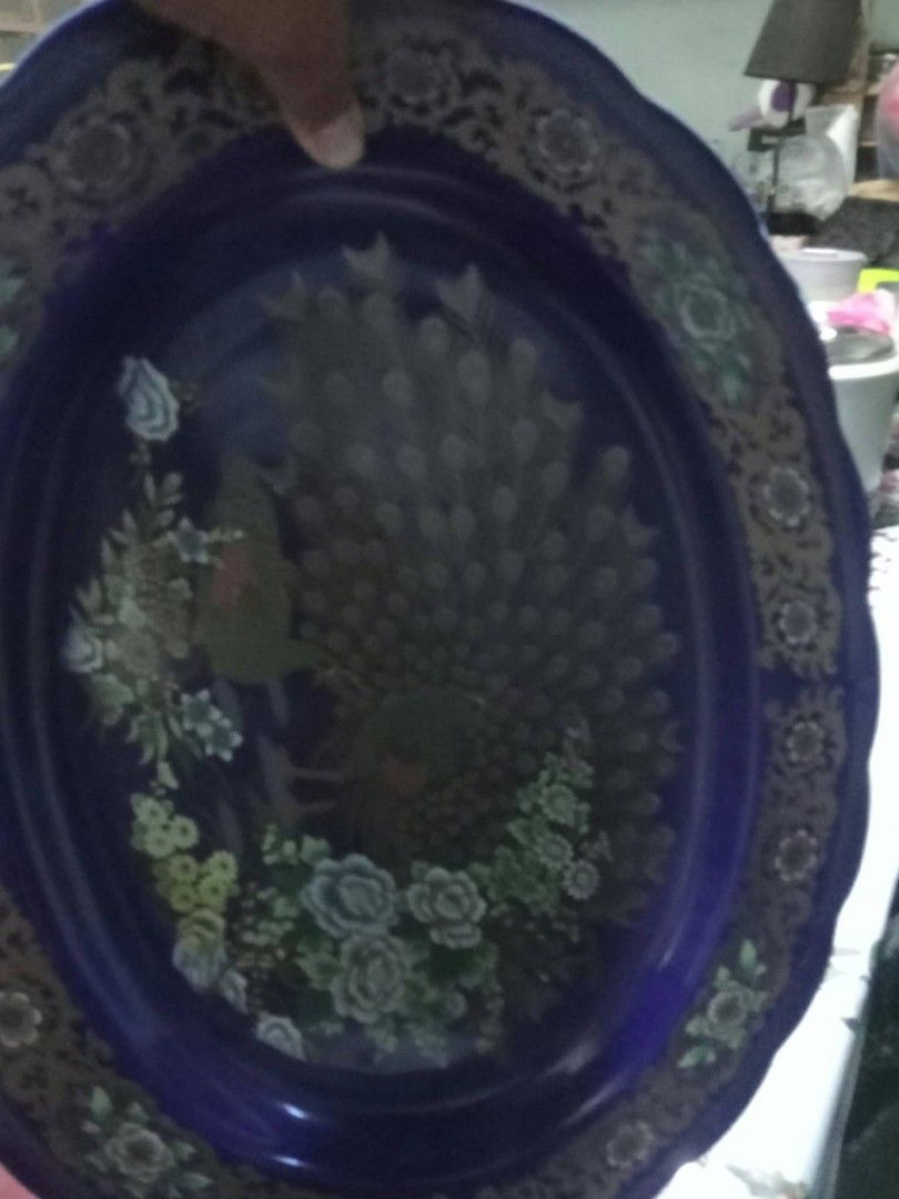 Vintage Royal Blue Ceramic Oval Serving Platter with Peacock Design (Category: Dinnerware & Cutlery) located in Manila. Submitted by wisegem-231b (Listing ID 1470403337, Image 3). Description: - Deep royal blue ceramic oval platter - Intricate gold filigree border with scalloped edges - Detailed peacock and floral bouquet artwork in the center - Maker stamp printed on the glazed bottom - Ideal serving piece for holidays and family gatherings.