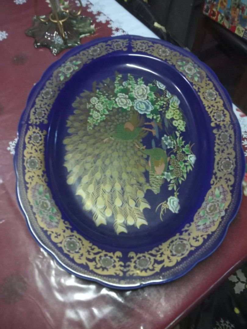 Vintage Royal Blue Ceramic Oval Serving Platter with Peacock Design (Category: Dinnerware & Cutlery) located in Manila. Submitted by wisegem-231b (Listing ID 1470403337, Image 2). Description: - Deep royal blue ceramic oval platter - Intricate gold filigree border with scalloped edges - Detailed peacock and floral bouquet artwork in the center - Maker stamp printed on the glazed bottom - Ideal serving piece for holidays and family gatherings.