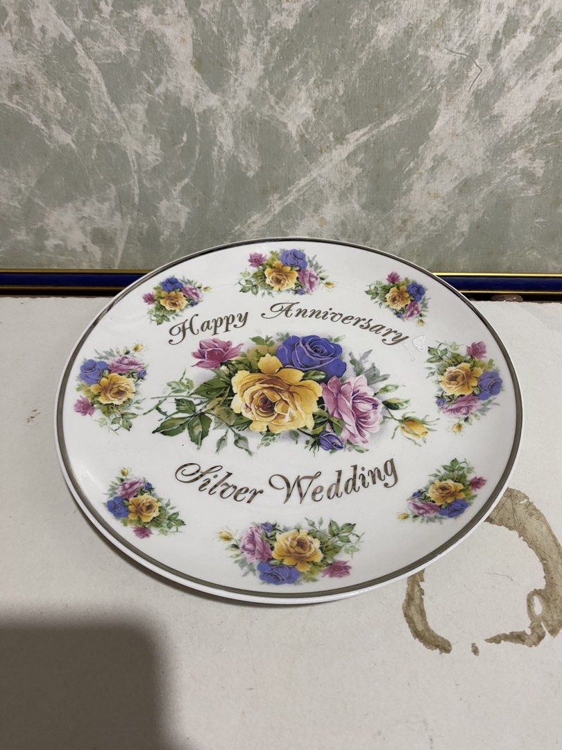 Vintage Silver Wedding Anniversary Decorative Ceramic Plate (Category: Dinnerware & Cutlery) located in Calamba. Submitted by chebvintagedepot (Listing ID 1470459330, Image 1). Description: (B22-04) White porcelain commemorative plate featuring a colourful bouquet of yellow, purple and pink roses in the centre, with smaller floral designs around the rim. Decorated with the wording “Happy Anniversary” and “Silver Wedding” in dark script. A lovely 