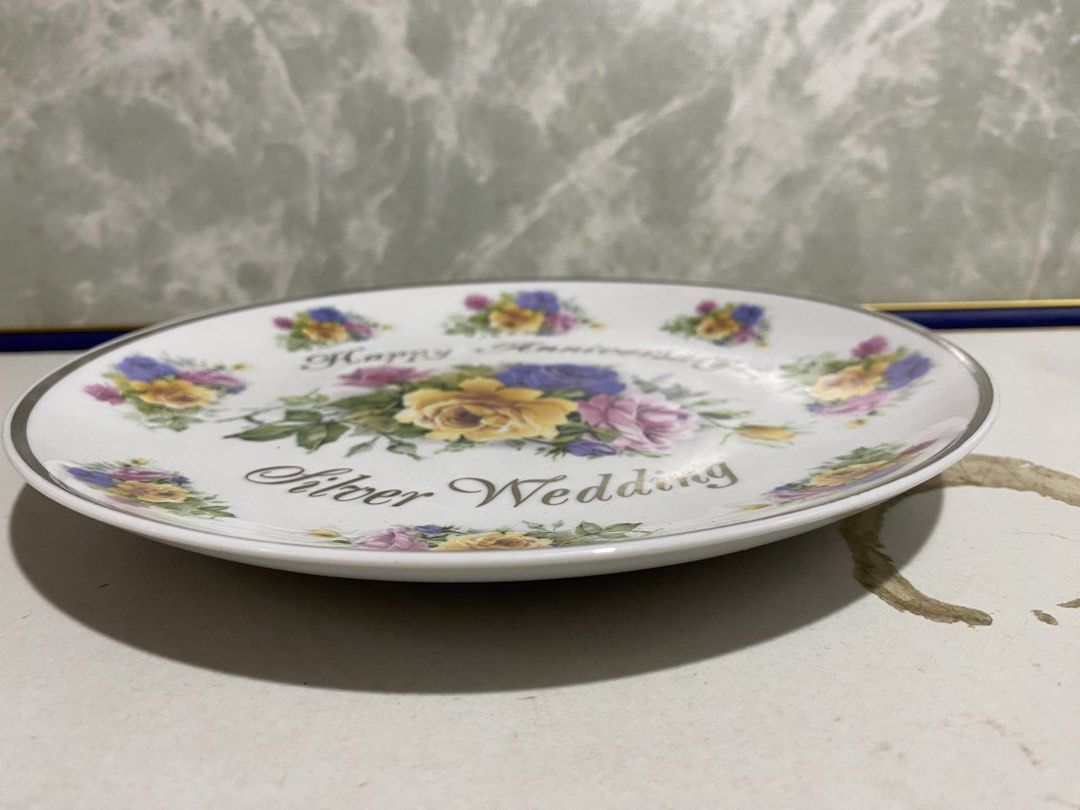 Vintage Silver Wedding Anniversary Decorative Ceramic Plate (Category: Dinnerware & Cutlery) located in Calamba. Submitted by chebvintagedepot (Listing ID 1470459330, Image 3). Description: (B22-04) White porcelain commemorative plate featuring a colourful bouquet of yellow, purple and pink roses in the centre, with smaller floral designs around the rim. Decorated with the wording “Happy Anniversary” and “Silver Wedding” in dark script. A lovely 