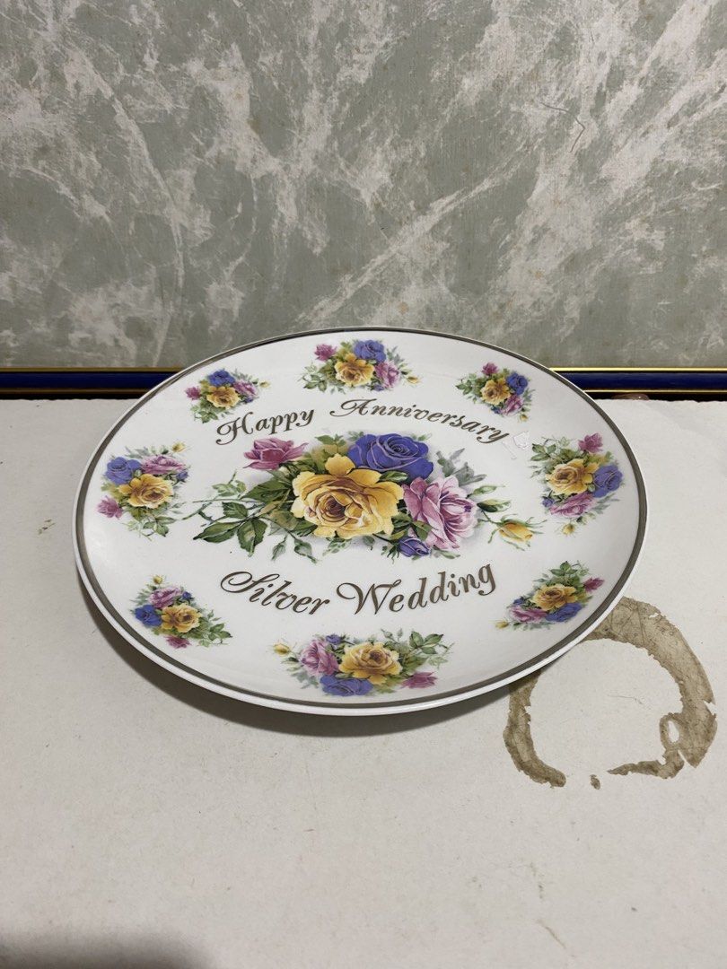 Vintage Silver Wedding Anniversary Decorative Ceramic Plate (Category: Dinnerware & Cutlery) located in Calamba. Submitted by chebvintagedepot (Listing ID 1470459330, Image 2). Description: (B22-04) White porcelain commemorative plate featuring a colourful bouquet of yellow, purple and pink roses in the centre, with smaller floral designs around the rim. Decorated with the wording “Happy Anniversary” and “Silver Wedding” in dark script. A lovely 