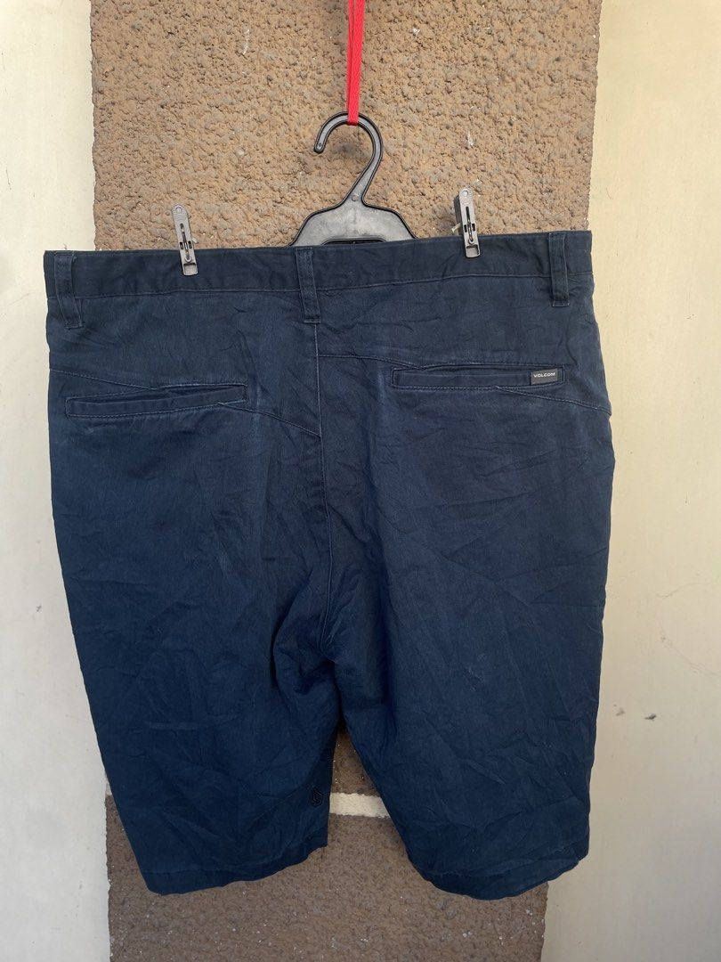 Volcom Navy Blue Casual Shorts size 34 (Category: Shorts) located in Quezon City. Submitted by dj052plo (Listing ID 1470426244, Image 1). Description: - Brand: Volcom - Color: Navy blue (solid) - Size: Standard fit with belt loops - Closure: Button and zipper fly - Pockets: Two back welt pockets with button closures - Details: Signature Volcom label tag on right back pocket - Condition: Good, slightly wrinkled from storage - Style: Great for ever