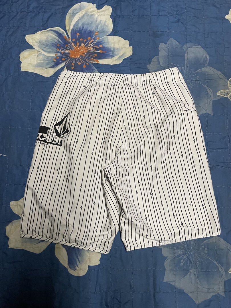 Volcom White and Black Striped Boardshorts (Category: Swim Trunks & Board Shorts) located in Manila. Submitted by chawmichael (Listing ID 1470473446, Image 3). Description: - Brand: Volcom - Color: White with vertical black pinstripes - Details: Small diamond logo prints throughout with large stone logo on left leg and back pocket - Waist: Adjustable white drawstring with secure closure - Storage: Side cargo pocket equipped with a key loop - Idea