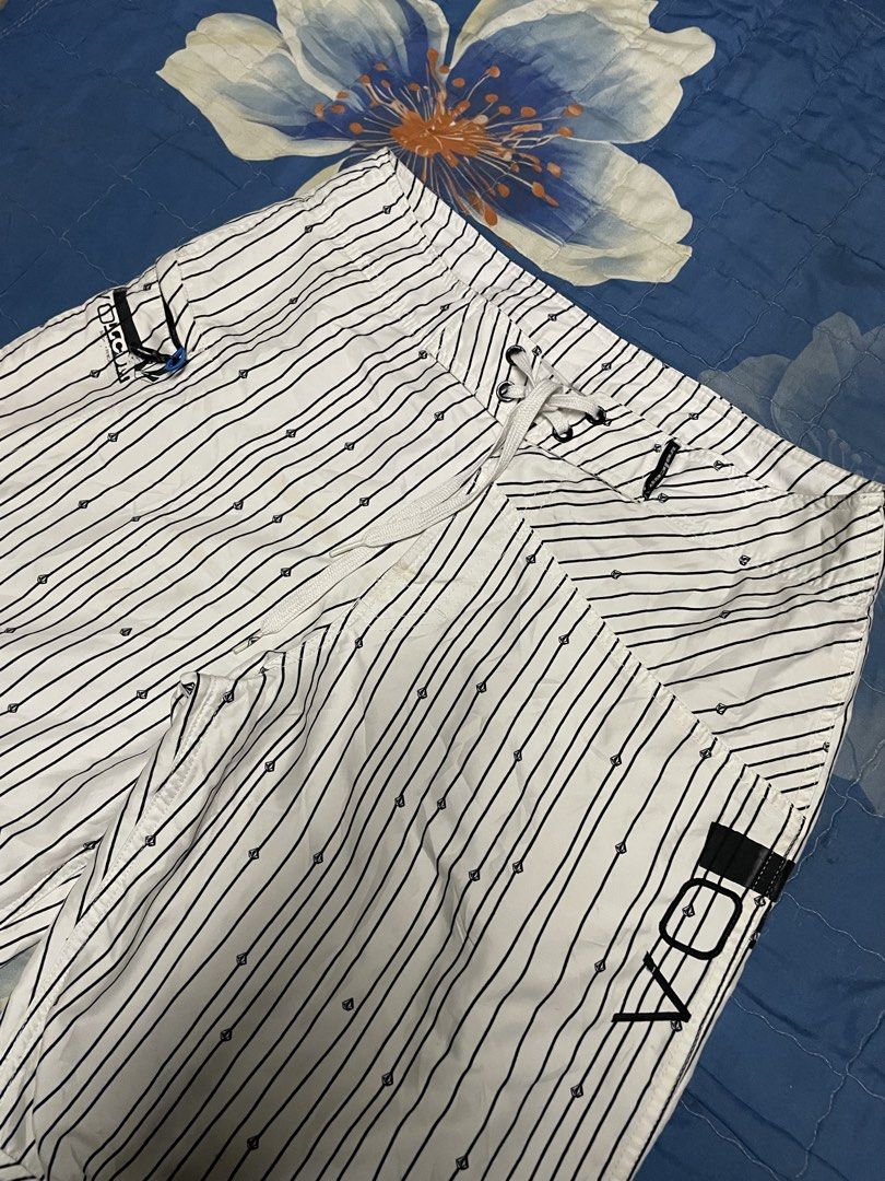 Volcom White and Black Striped Boardshorts (Category: Swim Trunks & Board Shorts) located in Manila. Submitted by chawmichael (Listing ID 1470473446, Image 2). Description: - Brand: Volcom - Color: White with vertical black pinstripes - Details: Small diamond logo prints throughout with large stone logo on left leg and back pocket - Waist: Adjustable white drawstring with secure closure - Storage: Side cargo pocket equipped with a key loop - Idea