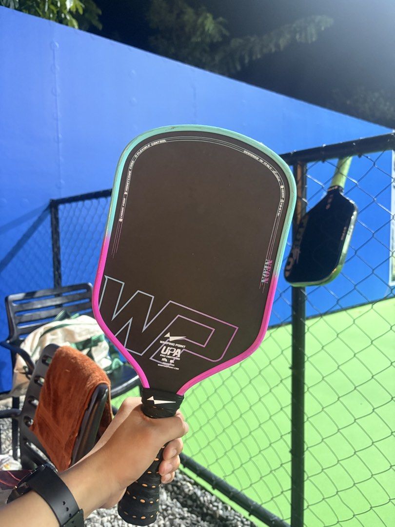 Warping Point Neon Gen 3 Pickleball Paddle (Category: Racket and Ball Sports) located in Tarlac. Submitted by joshcutie (Listing ID 1470507531, Image 2). Description: - Model: Warping Point Neon Pickleball Paddle - Colorway: Sleek black with vibrant turquoise and pink gradient edges - Build: Premium carbon fiber face with a 16mm honeycomb core design - Certification: UPA pro certified for competitive play - Handle: Textured grip featuring stylish