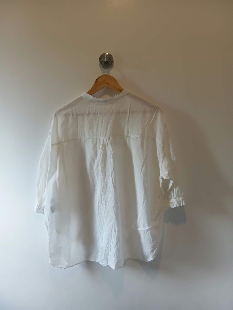 White Button Up Blouse Mandarin Collar Size S-M (Category: Blouses) located in Antipolo. Submitted by wisecat.4a7eea (Listing ID 1470399248, Image 2). Description: - Color: Classic White - Design: Mandarin collar, half sleeves, back yoke with slight gathering - Fit: Relaxed fit, high-low curved hemline, fits small to medium frames - Material: Light fabric with a soft drape - Styling: Versatile basic piece, easy to match with jeans or skirts for c