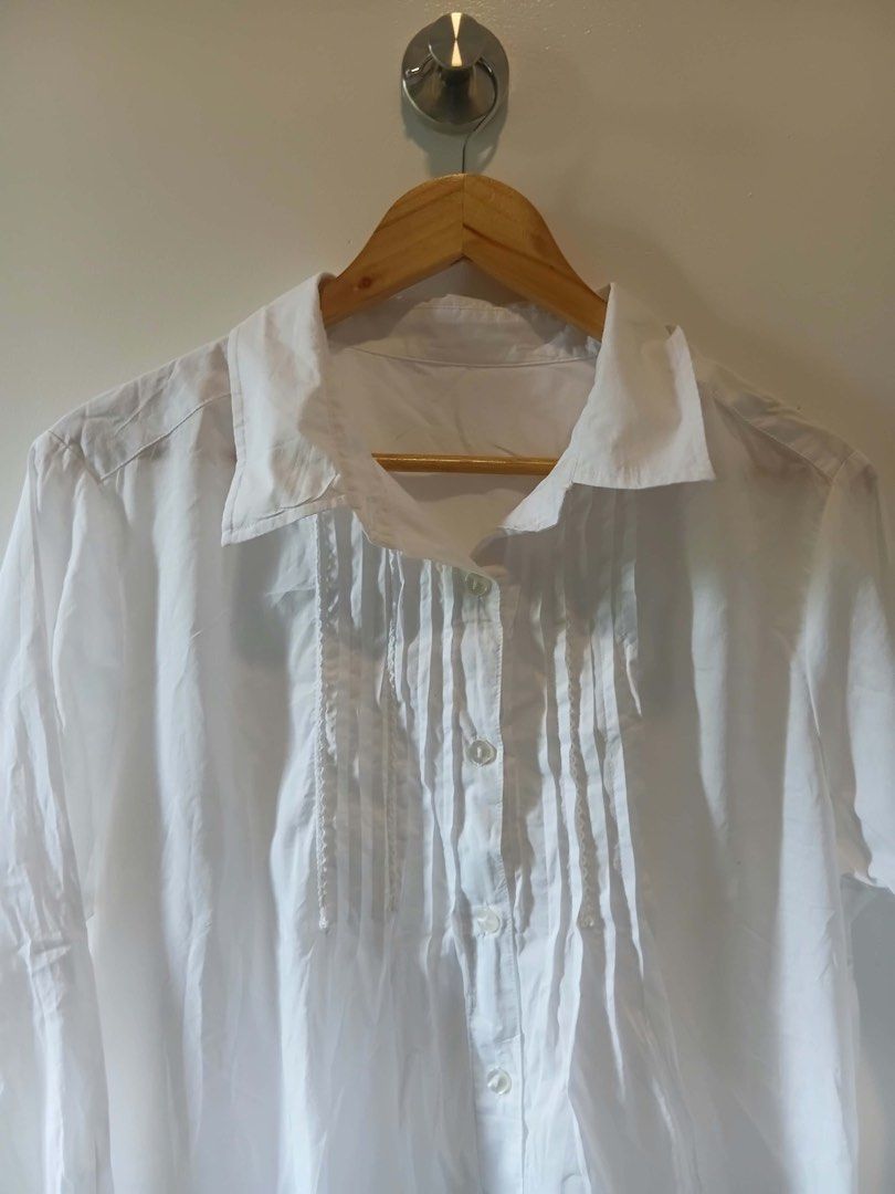 White Button-Up Blouse with Pleated Front Details L-XL (Category: Blouses) located in Antipolo. Submitted by wisecat.4a7eea (Listing ID 1470399601, Image 3). Description: - Color: White - Fit: Relaxed, fits Large to Extra Large - Style: Long-sleeve button-down with unique pleated vertical chest panels - Details: Standard collar and button cuffs - Versatility: Perfect for casual days or office wear - Fabric: Lightweight (needs a quick iron before 