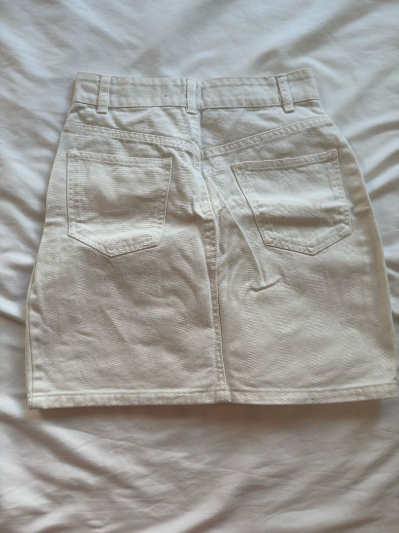 White denim mini skirt with pockets S (Category: Skirts) located in Cebu City. Submitted by _t.rix (Listing ID 1470373130, Image 2). Description: - Style: High-waisted white denim mini skirt - Material: Heavy cotton, structured shape with clean stitching - Details: Belt loops, two back patch pockets, and one front patch pocket with a brown button accent - Size: Flat waist measures approx. 13.5 inches across - Condition: Excellent, no noticeable f