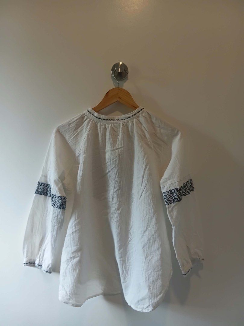 White Embroidered Long Sleeve Blouse Size S-M (Category: Longsleeves) located in Antipolo. Submitted by wisecat.4a7eea (Listing ID 1470398375, Image 3). Description: - Color: White with dark blue embroidery - Design: Long-sleeve, loose fit - Details: Keyhole front closure with a single white button - Condition: Clean and ready to wear.