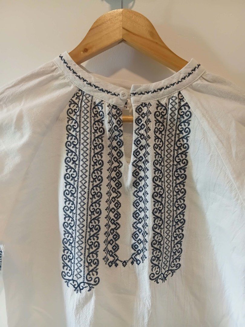 White Embroidered Long Sleeve Blouse Size S-M (Category: Longsleeves) located in Antipolo. Submitted by wisecat.4a7eea (Listing ID 1470398375, Image 2). Description: - Color: White with dark blue embroidery - Design: Long-sleeve, loose fit - Details: Keyhole front closure with a single white button - Condition: Clean and ready to wear.