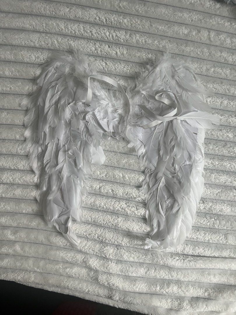 White Feather Angel Wings Costume Accessory (Category: Coats, Jackets and Outerwear) located in Manila. Submitted by xiaotingworld (Listing ID 1470385755, Image 2). Description: - Color/Style: White feathered angel wings - Features: Fluffy texture, lightweight design, and easy-to-wear elastic shoulder straps - Perfect for: Dress-up, cosplay, Halloween, and photo shoots - Condition Note: Has minor tears on the inner backing paper near the straps (