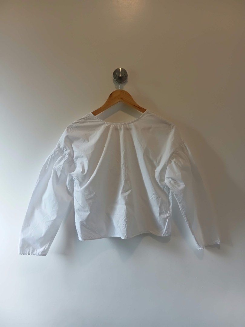 White long sleeve button down blouse (Category: Longsleeves) located in Antipolo. Submitted by wisecat.4a7eea (Listing ID 1470399709, Image 2). Description: - Color: White - Style: Clean, minimal design with front button closures - Details: V-neckline, trendy puffed sleeves, and gathered back accent - Fit: Comfortable medium to large (M-L) - Versatility: Easy to style with both skirts and trousers.