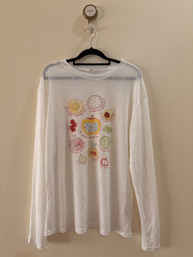 White Long Sleeve Fruit Graphic shirt (Category: Longsleeves) located in Manila. Submitted by anabri (Listing ID 1470371849, Image 1). Description: - Brand: TOPFEELING - Size: M can fit up to L - loose fit - Style: Long sleeve crew neck top - Design: Quirky fruit & clock graphics with playful misspelled text ("PLUEBFPPY ALAPM") - Fabric: Lightweight, semi-sheer with a bit of stretch - Condition: Great casual piece, ready to wear - LAST 2 PHOTOS F
