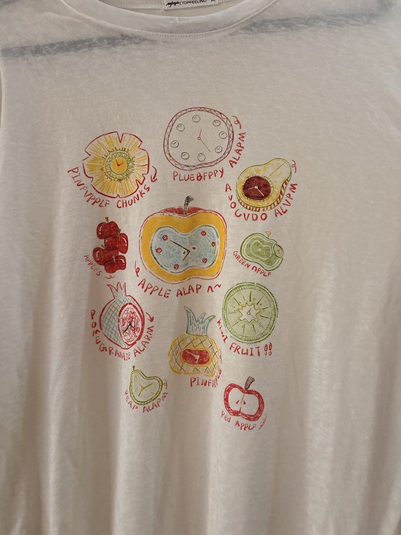 White Long Sleeve Fruit Graphic shirt (Category: Longsleeves) located in Manila. Submitted by anabri (Listing ID 1470371849, Image 3). Description: - Brand: TOPFEELING - Size: M can fit up to L - loose fit - Style: Long sleeve crew neck top - Design: Quirky fruit & clock graphics with playful misspelled text ("PLUEBFPPY ALAPM") - Fabric: Lightweight, semi-sheer with a bit of stretch - Condition: Great casual piece, ready to wear - LAST 2 PHOTOS F