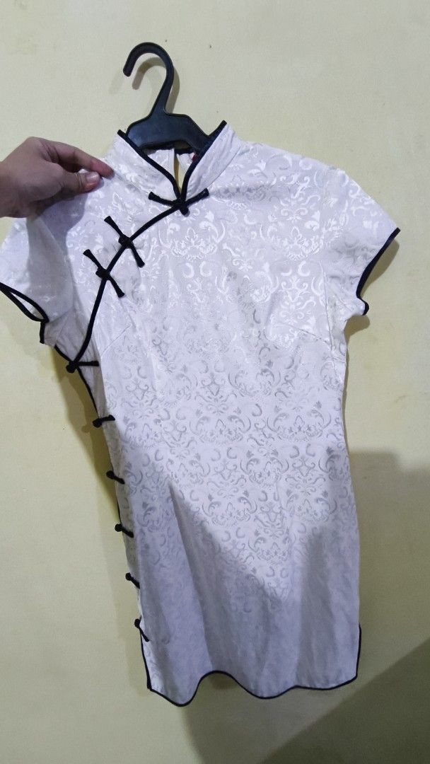 White Mandarin Collar Mini Dress Traditional (Category: Dresses) located in Manila. Submitted by jnhviola (Listing ID 1470437897, Image 1). Description: - Color: White with intricate silver brocade pattern - Design: Traditional mandarin collar, decorative fabric knot buttons, and contrasting black piping - Fit: Structured short-sleeve mini dress - Closure: Concealed back zipper for easy wear - Condition: PRELOVED; LIKED-NEW - Mode of Payment: BDO