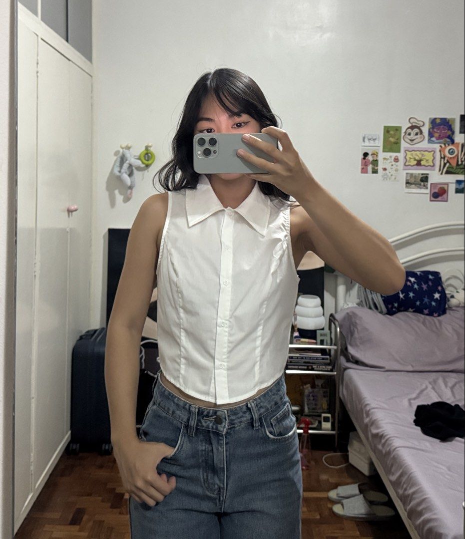 White sleeveless collared crop button down shirt top (Category: Blouses) located in Angeles City. Submitted by m1lkramen (Listing ID 1470464226, Image 2). Description: - Color: White - Size: XS (tagged inside collar) - Style: Sleeveless, cropped, collared top with front button closure - Fit: Tailored through the body with structured lapels - Condition: Clean fabric, great basic for layering or standalone wear · · ─ ·✶· ─ · · length: 15.5 in width