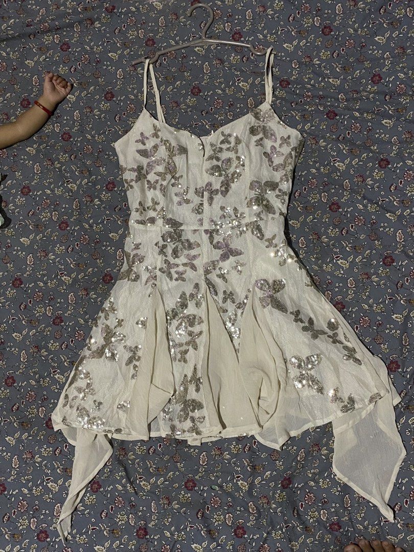White Spaghetti Strap Dress With Sequin Butterfly Pattern (Category: Dresses) located in Manila. Submitted by brightwind.f4384c (Listing ID 1470453684, Image 1). Description: - Color & Pattern: White with shimmering silver sequin butterfly designs - Neckline & Straps: Sweetheart neckline with thin, adjustable straps - Fit & Style: Fitted bodice with a flared, flowy handkerchief hemline - Occasion: Ideal for parties, clubs, and night outs - Care I