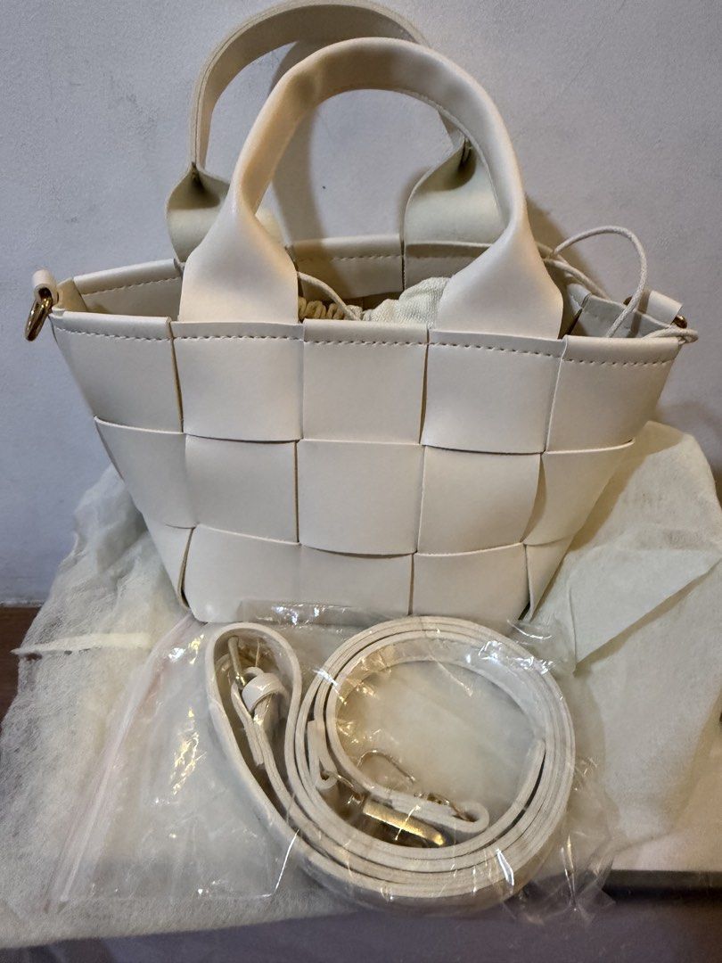 White Woven Leather Bucket Bag with Strap (Category: Shoulder Bags) located in Bulacan. Submitted by emjay_17 (Listing ID 1470408159, Image 1). Description: - Color & Material: White woven faux leather - Design: Structured checkerboard pattern - Features: Top handles and a secure drawstring inner pouch - Strap: Includes an adjustable, detachable matching white shoulder strap (still wrapped in plastic) - Condition: Brand new, never used, with a pe